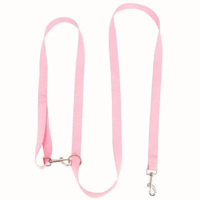 une laisse rose pour chien main libre avec une poignee et un clip metallique