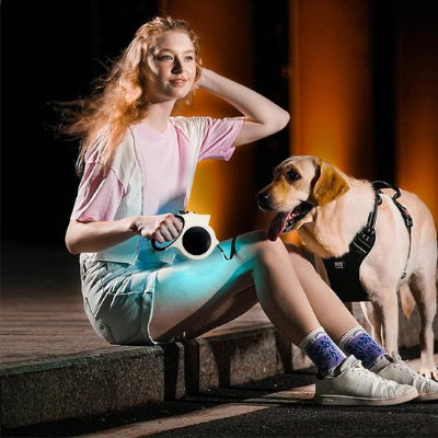 Femme assise utilisant une laisse chien enrouleur avec led pour promener son beagle